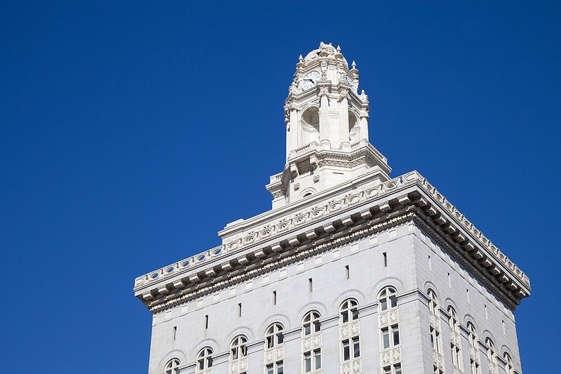 White ornate building with a clock tower against a blue sky.