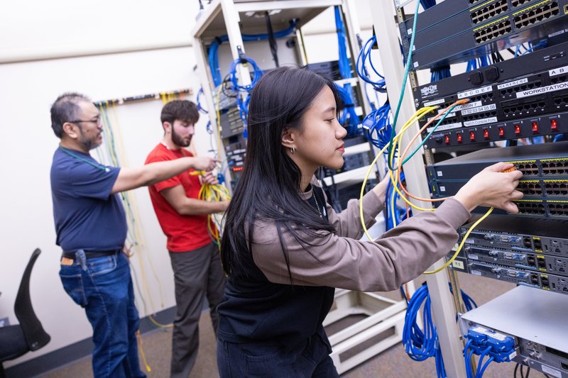 An intern plugs looks at the wiring of technology