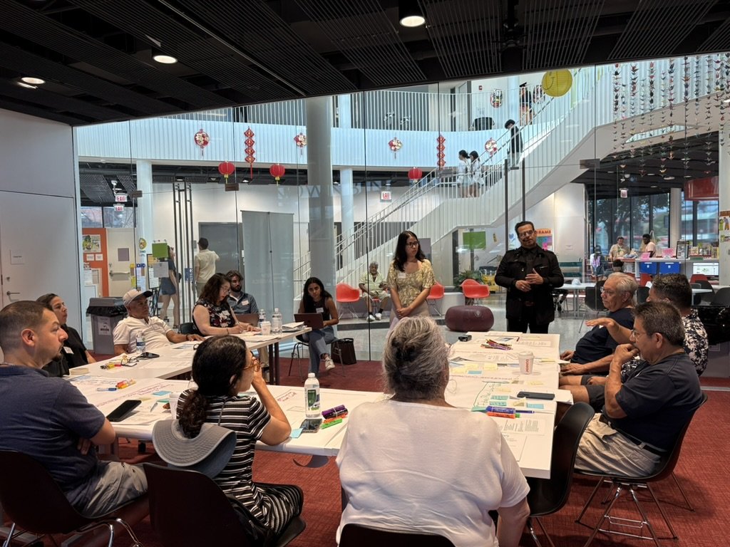 People gathered around a table in a modern, open space with large windows.