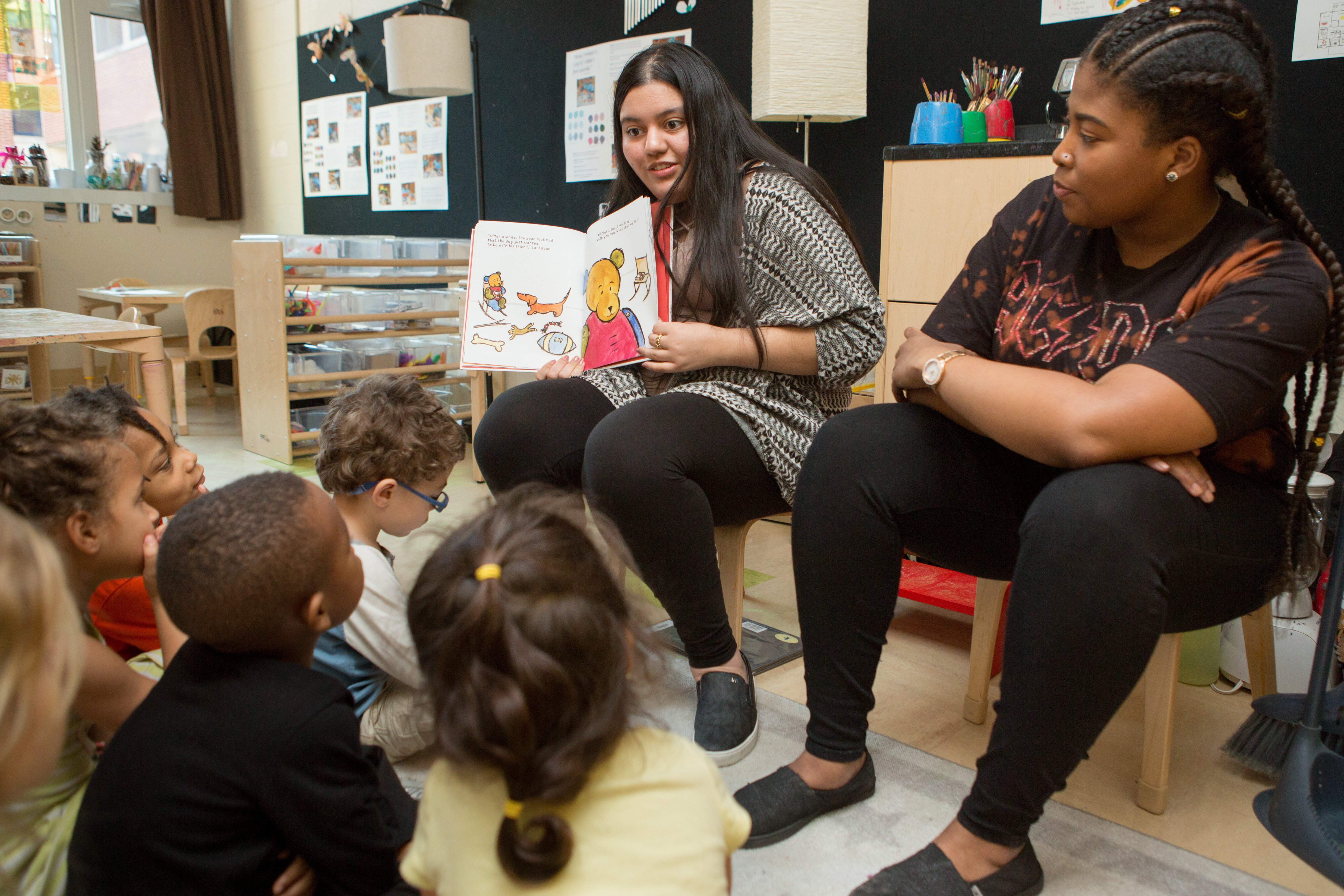 high school student reads to preschool class