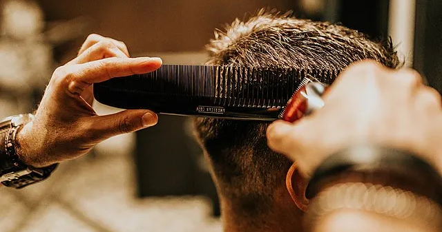 Barber_cutting_hair_with_comb._Back_view_of_man_in_barber_shop