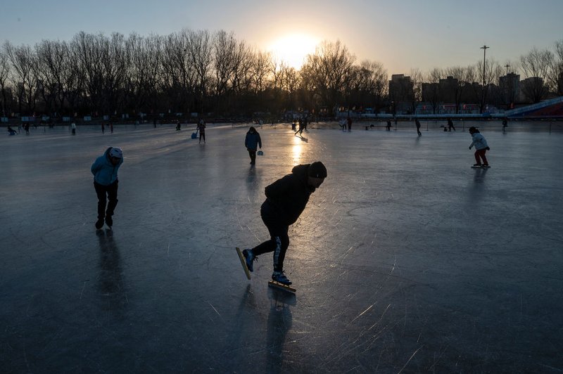 People skate together on a lake in a local park.