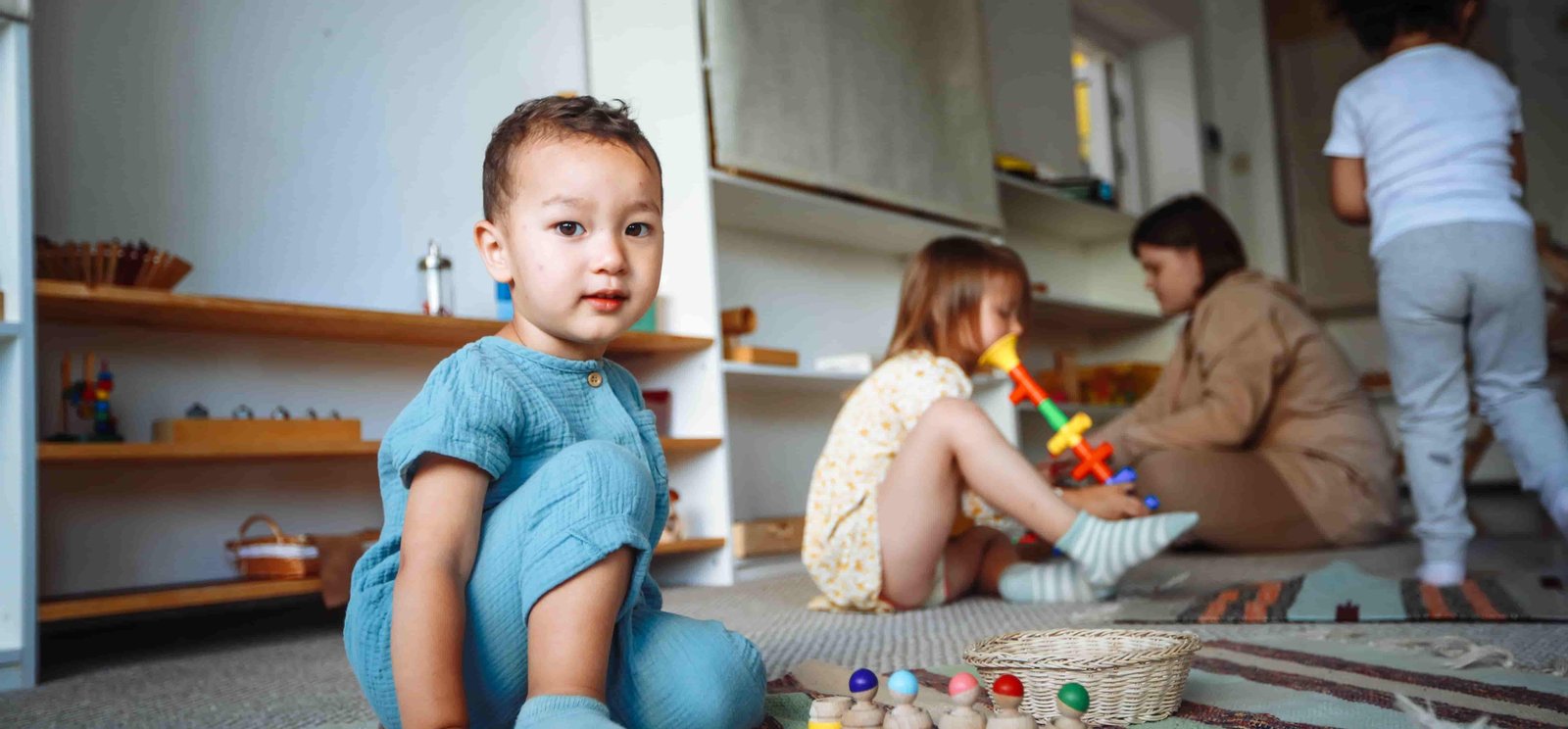 Children playing with toys in a well-lit playroom.