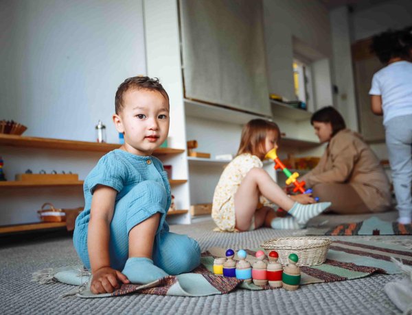 Children playing with toys in a well-lit playroom.