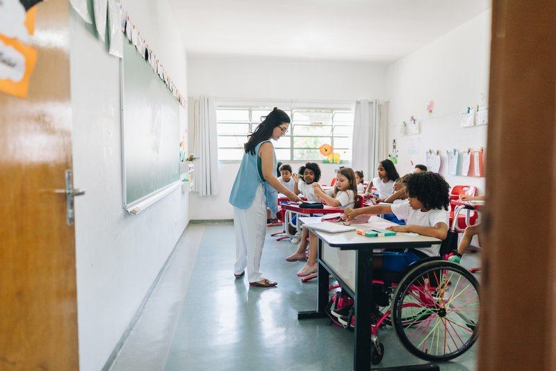 Teacher teaching in a classroom of students with disabilities at school.