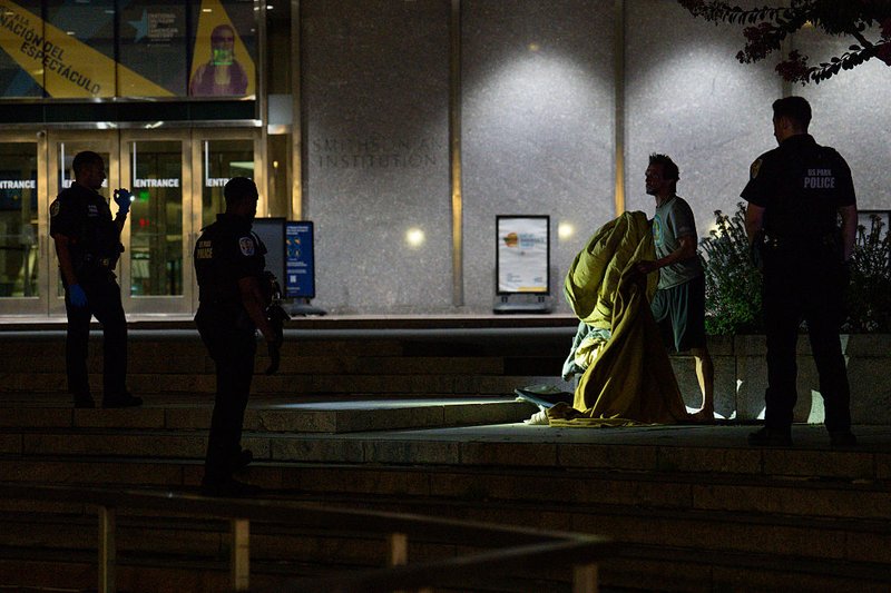 U.S. Park Police remove a homeless individual from the steps of the Smithsonian National Museum of American History in Washington.