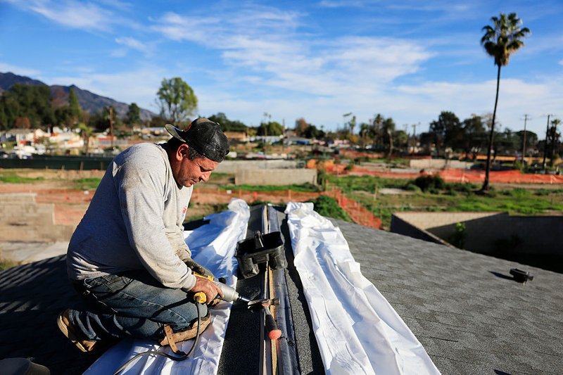 A worker helps assemble an ADU (accessory dwelling unit) for Eaton Fire survivors.