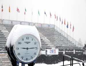 Snow falls over clock.