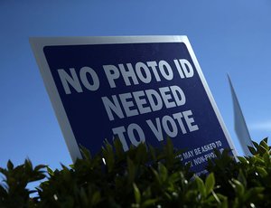 A "No Photo ID Needed To Vote" sign is seen outside a county government center for early voting.