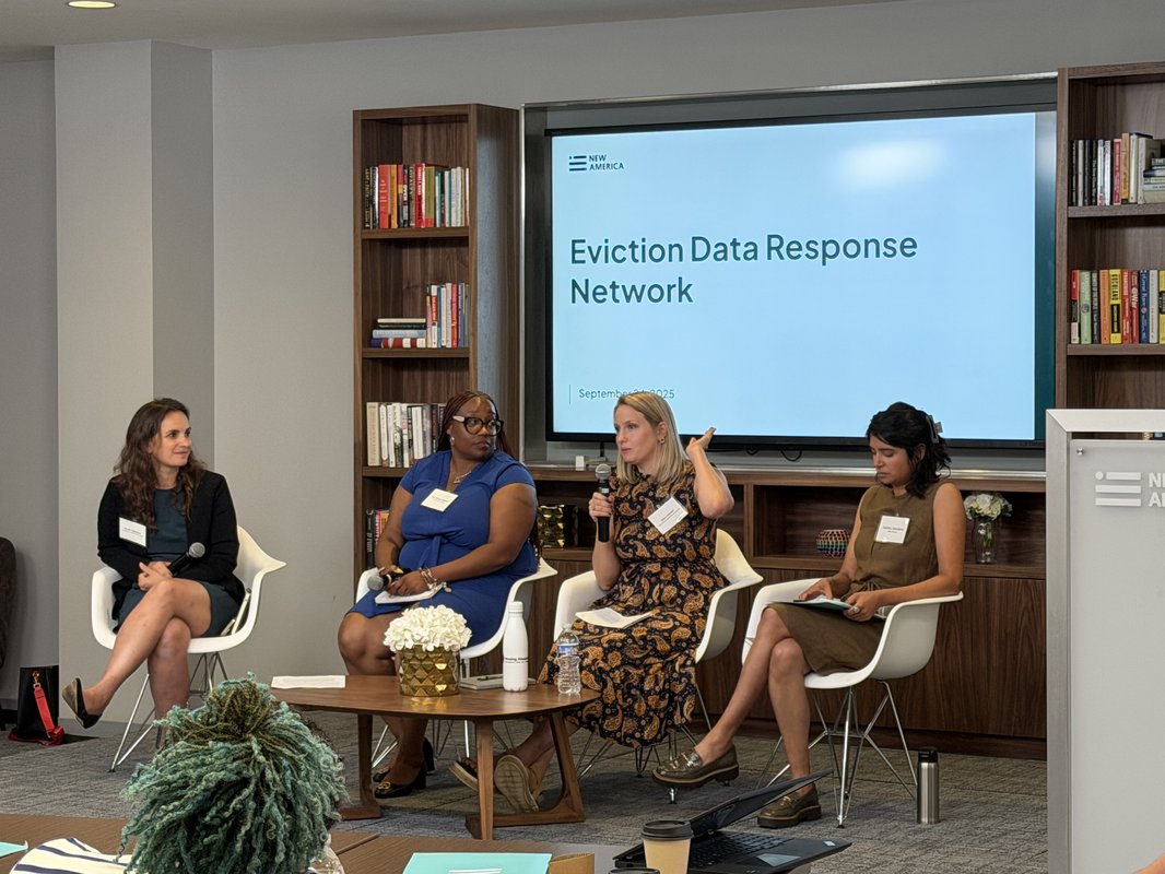 Four panelists speaking on a stage.