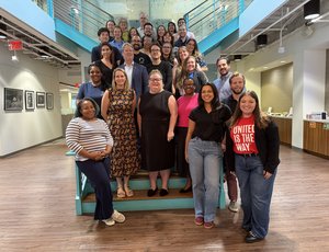 Over 30 people pose for a picture on the staircase in New America's office.