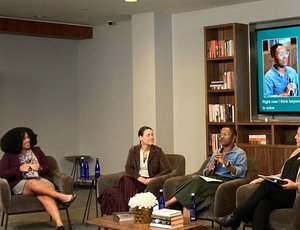 One moderator and three panelists sit in chairs at New America and two are pictured on a large screen as virtual participants.