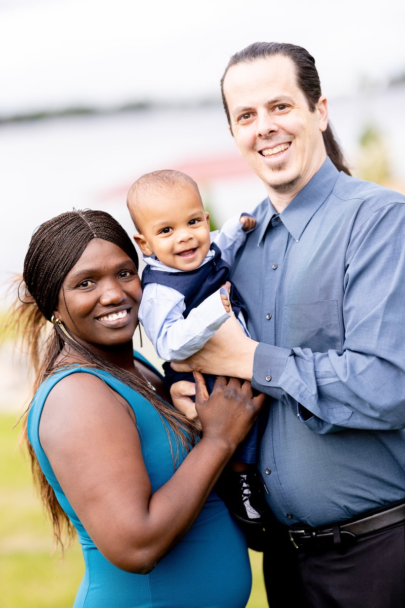 A picture of Maimouna and her husband, holding their young son in their arms.