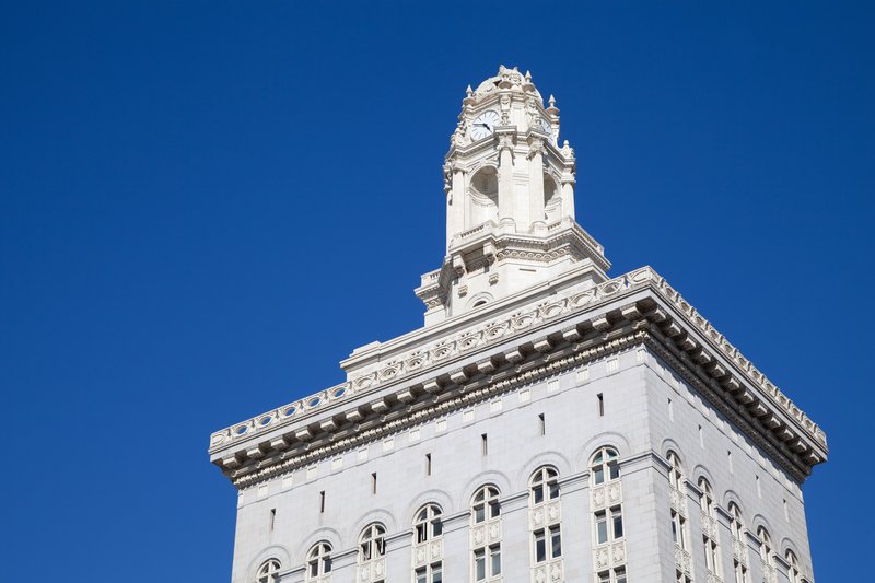 White ornate building with a clock tower against a blue sky.