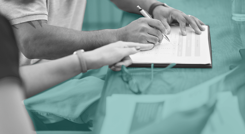 Close-up of people signing and handling document ledger on desk, with teal coloring.