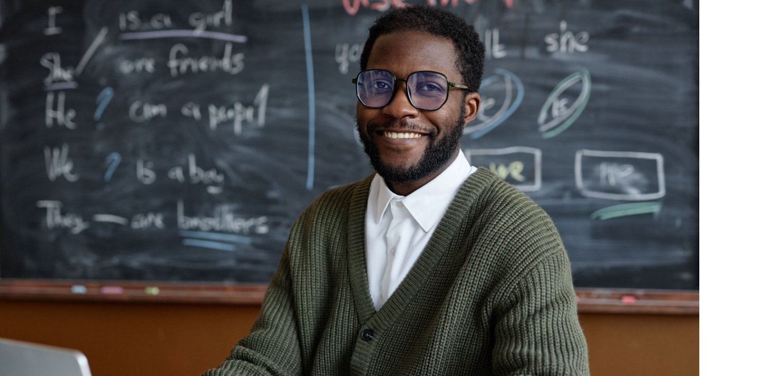 Teacher with computer and blackboard