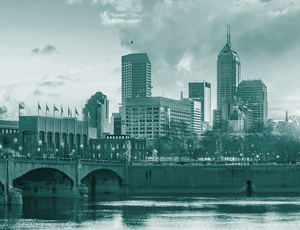 A bridge crosses a river toward a city skyline, with a teal overlay.