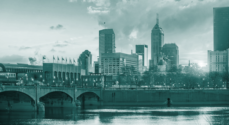 A bridge crosses a river toward a city skyline, with a teal overlay.