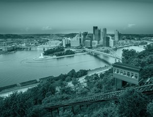 Two bridges connect a town with skyline across both sides of a forked river.