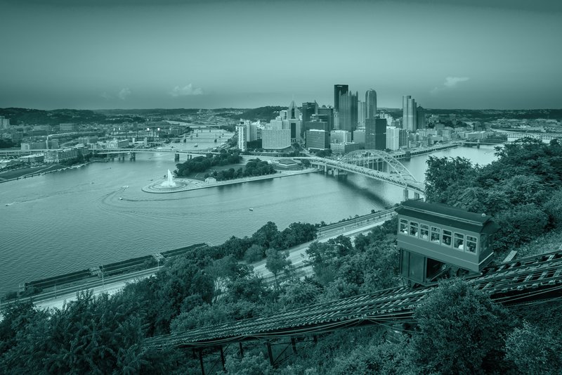 Two bridges connect a town with skyline across both sides of a forked river.
