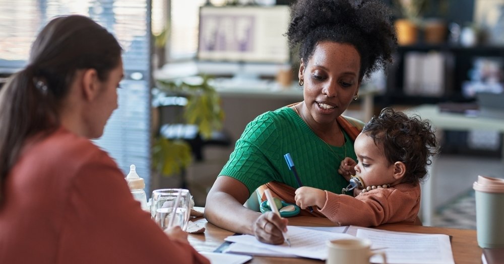 Black student parent with child in front of desk