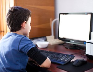 A child sits at a computer.