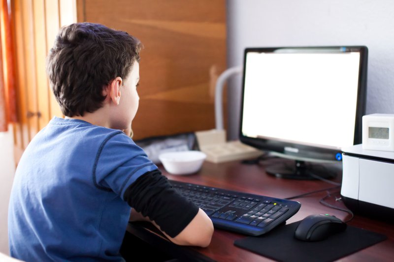 A child sits at a computer.