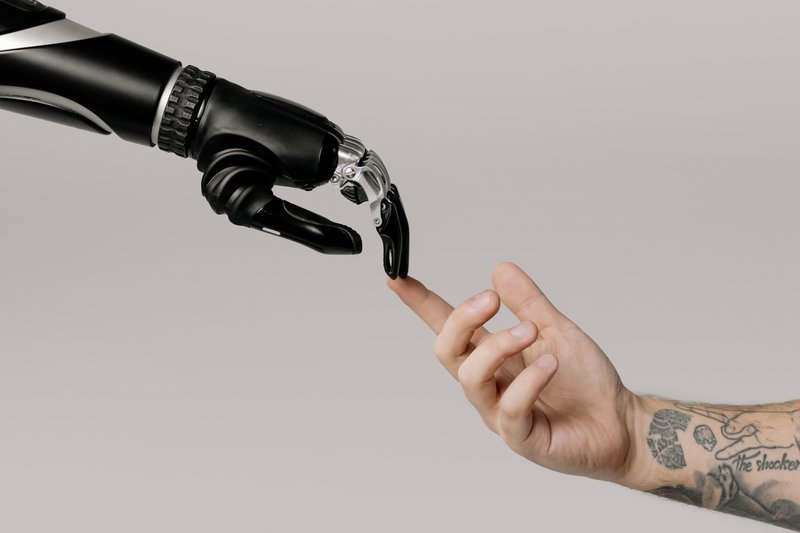 A robotic hand stretched out touching a human hand | Credit: Pexels