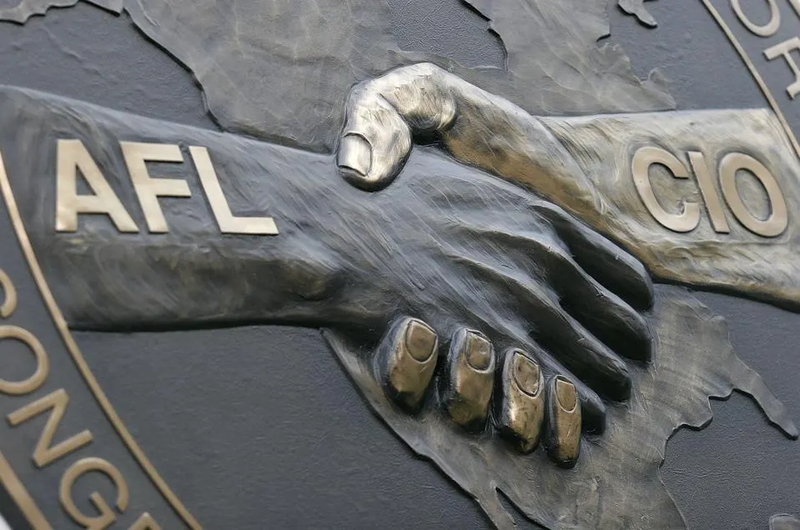 Two hands shaking labeled as AFL and CIO-- the AFL-CIO signage.