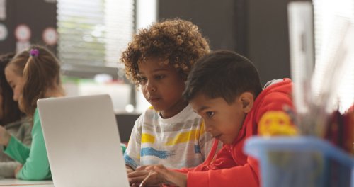 Two students using laptop