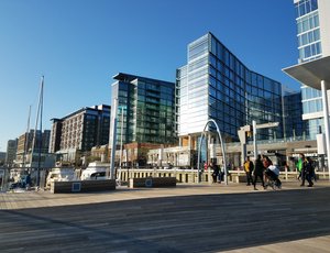 Boats are docked below shiny glass and brick buildings at the Wharf in southeast DC.