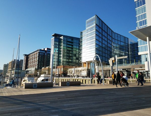 Boats are docked below shiny glass and brick buildings at the Wharf in southeast DC.