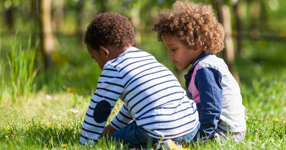 two boys playing in grass