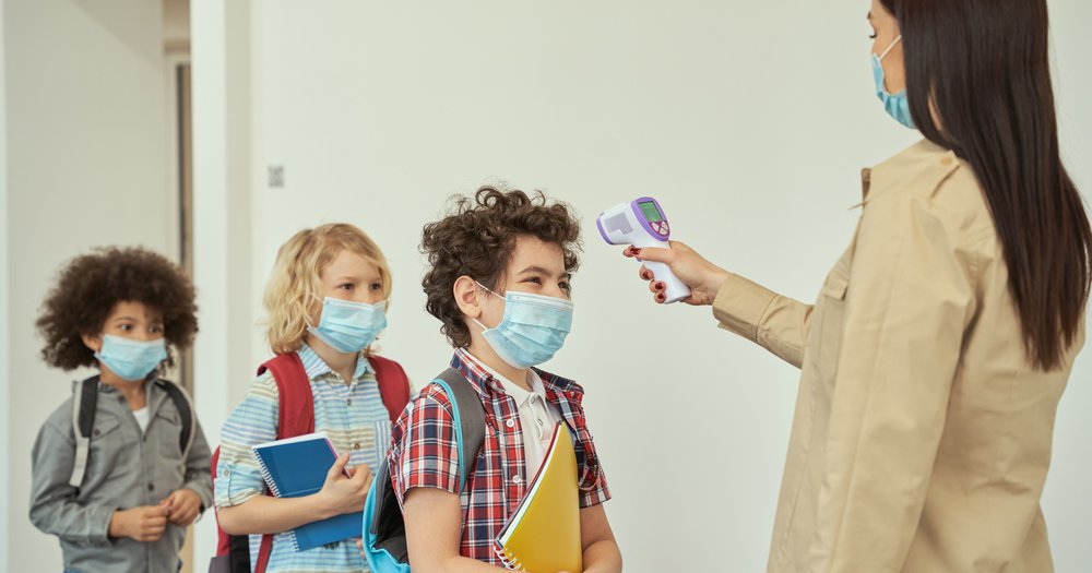 Teacher checks students temp COVID