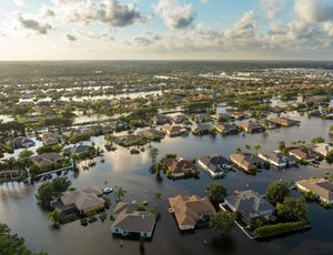 Aerial view of a flooded suburban neighborhood with houses partially submerged.
