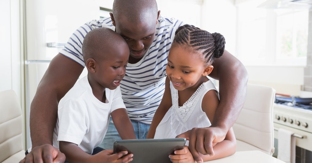Black father and kids on ipad