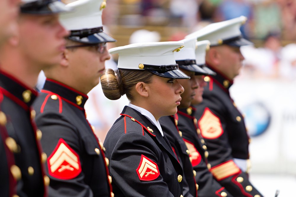 US Military service men and women stand in formation for the national anthem