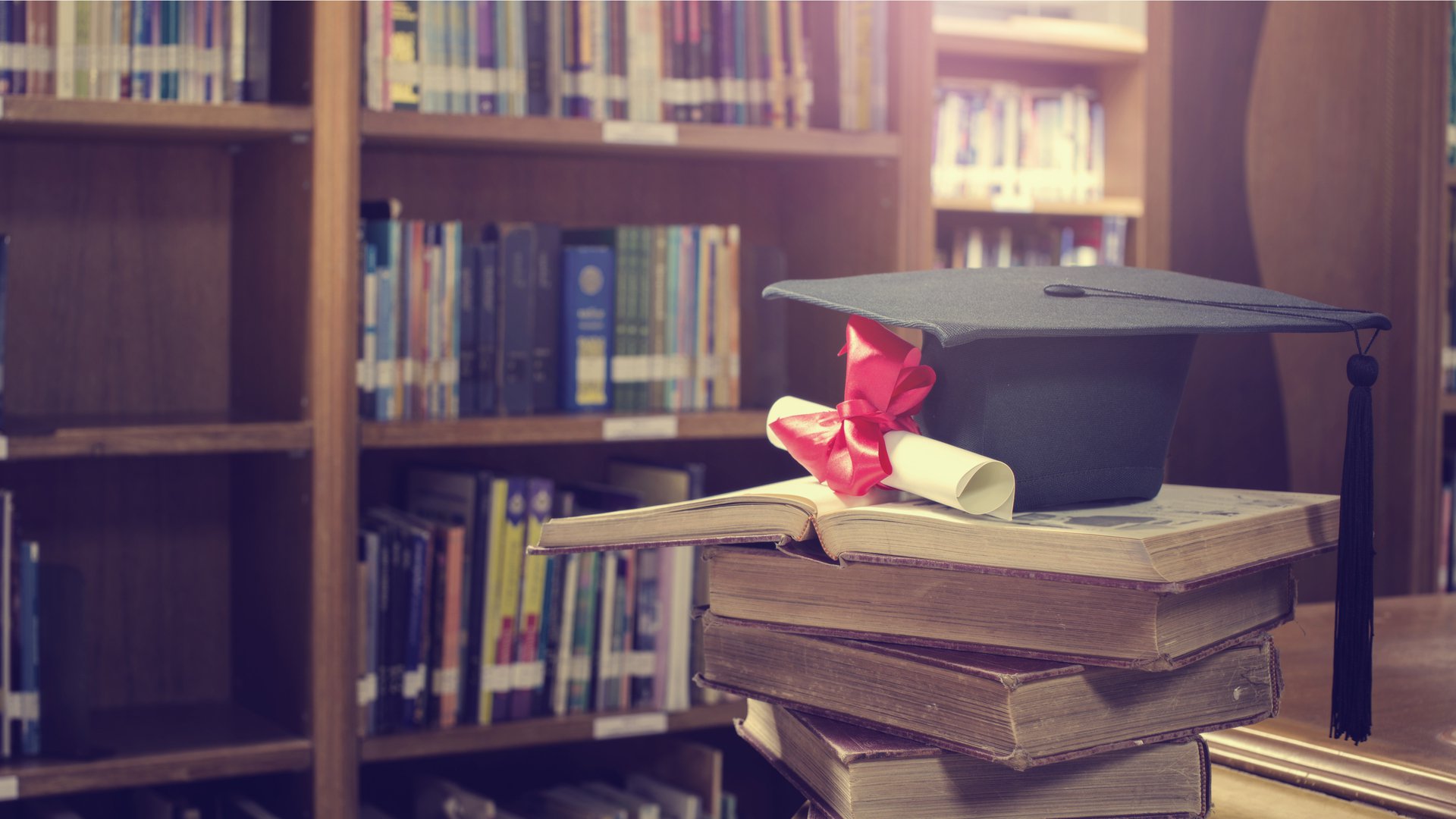 Cap, Gown, and Diploma in Library