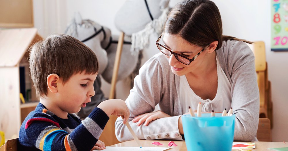Teacher giving pre-K student a test