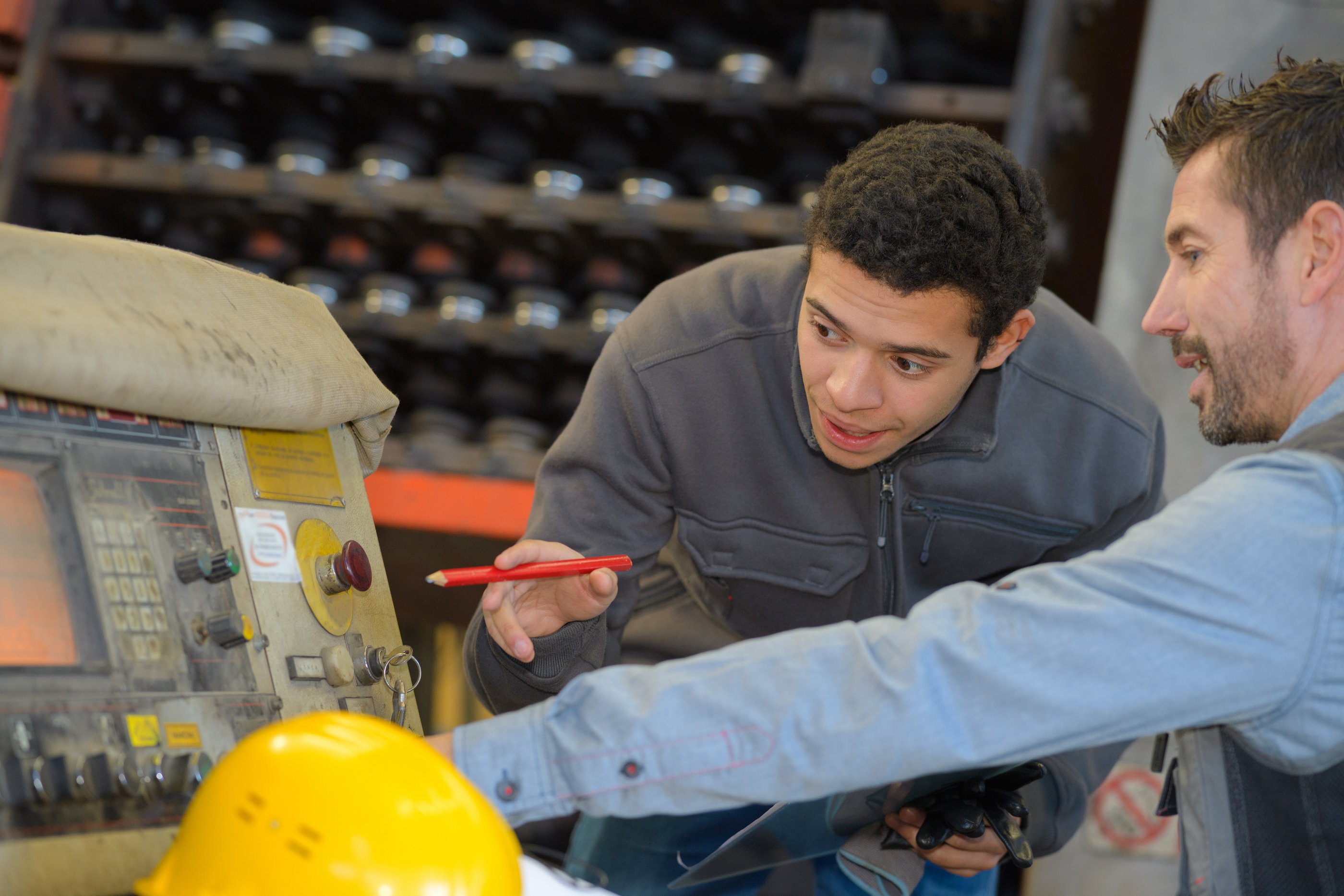Trainee learning how to use a machine at the factory